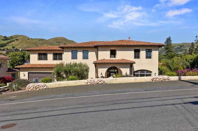 mediterranean / spanish-style home featuring a mountain view and a garage