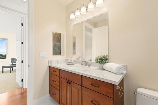 bathroom with hardwood / wood-style floors, toilet, and vanity