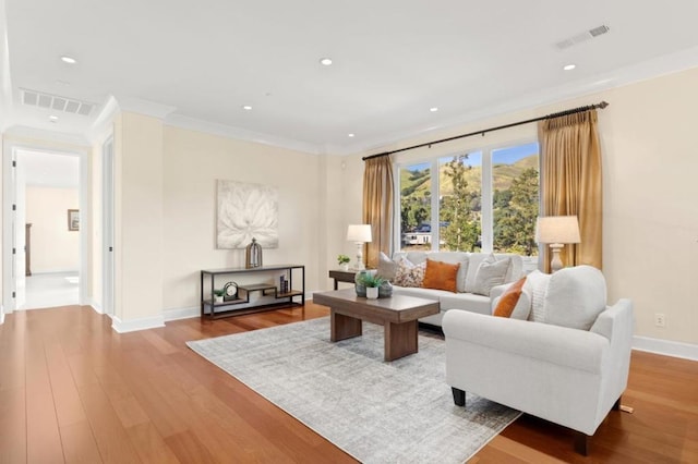 living room featuring crown molding and hardwood / wood-style flooring