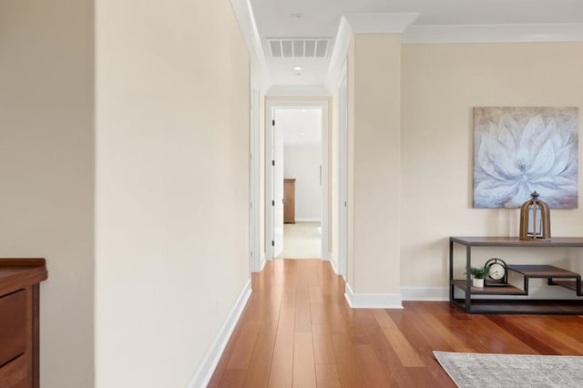 hallway featuring light hardwood / wood-style flooring and ornamental molding