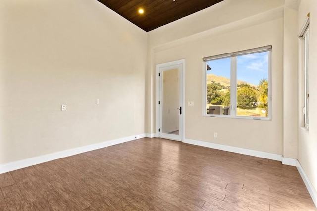 unfurnished room featuring wood ceiling, vaulted ceiling, and hardwood / wood-style flooring