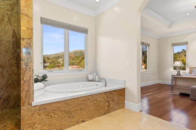 bathroom featuring wood-type flooring, a bath, and ornamental molding