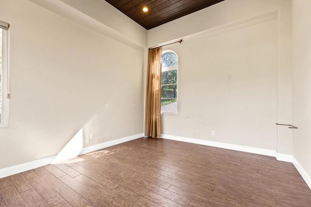 spare room with dark wood-type flooring and wood ceiling