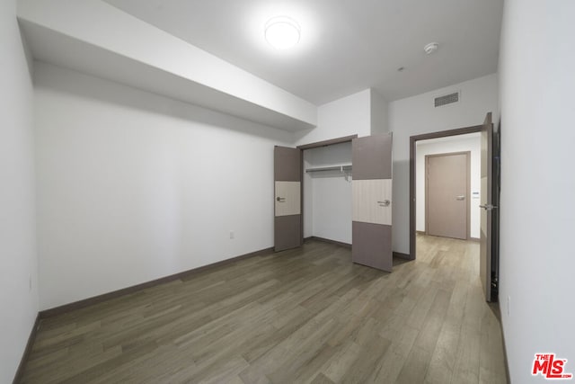 unfurnished bedroom featuring a closet and dark hardwood / wood-style flooring