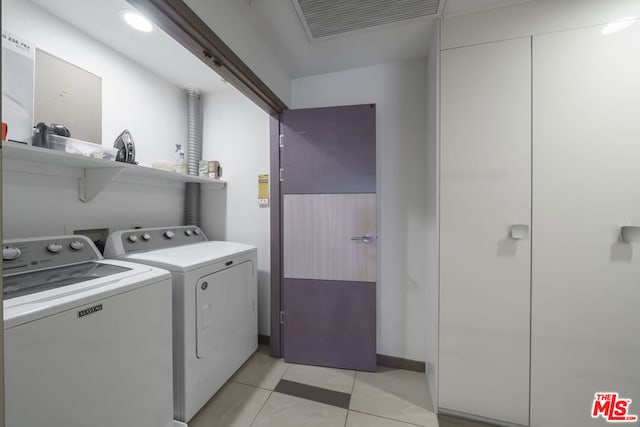 laundry room with light tile patterned floors and washing machine and clothes dryer