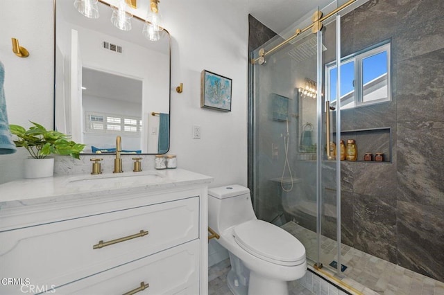 bathroom featuring a shower with door, toilet, and vanity