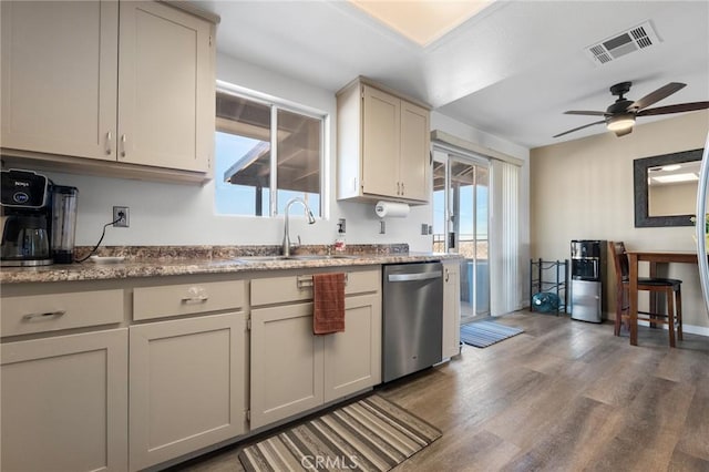 kitchen with hardwood / wood-style flooring, ceiling fan, stainless steel dishwasher, cream cabinets, and sink