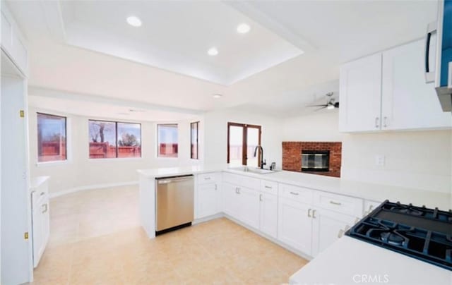 kitchen featuring white cabinetry, sink, stainless steel dishwasher, and kitchen peninsula