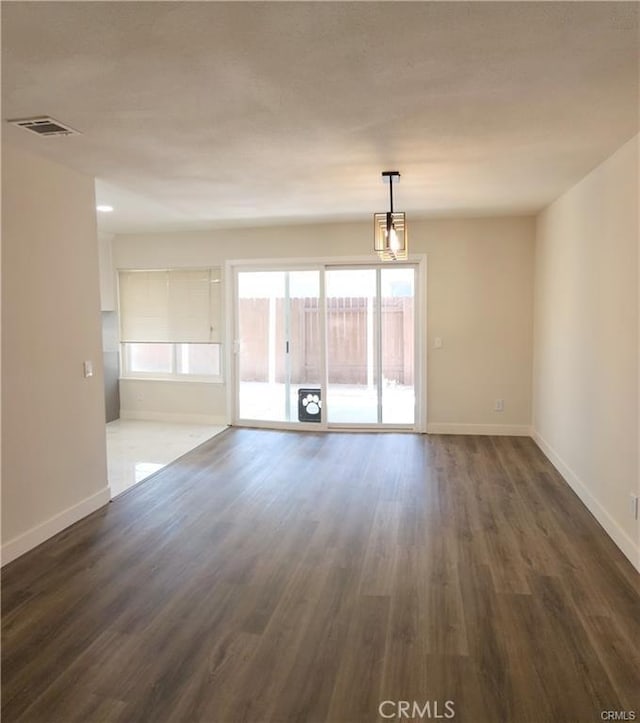 spare room featuring dark wood-type flooring