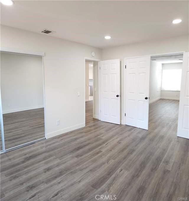 unfurnished bedroom featuring a closet and dark hardwood / wood-style flooring