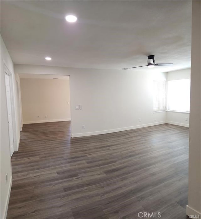 empty room featuring ceiling fan and dark wood-type flooring