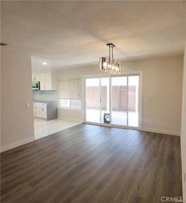 unfurnished living room featuring dark hardwood / wood-style floors and a chandelier