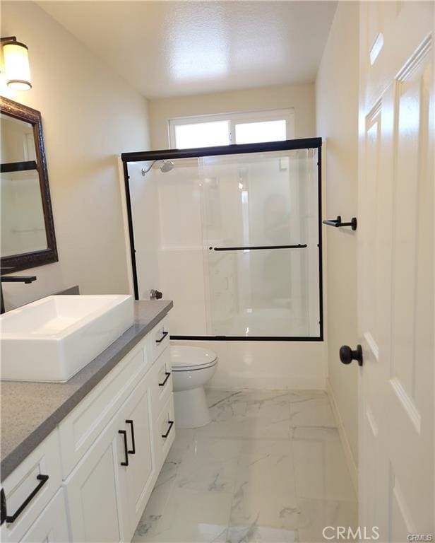 full bathroom with shower / bath combination with glass door, vanity, and toilet