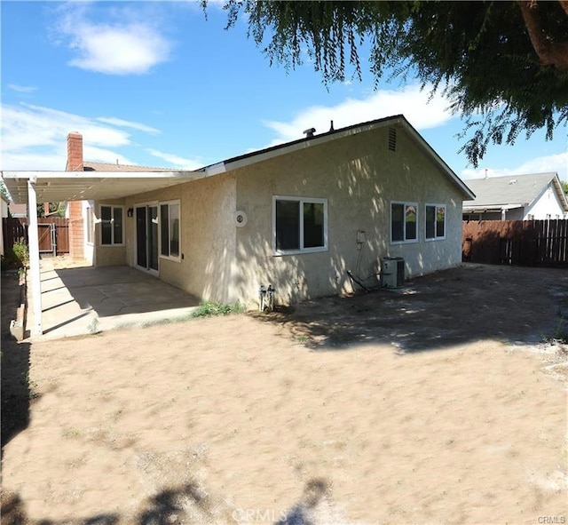 rear view of property with central air condition unit and a patio