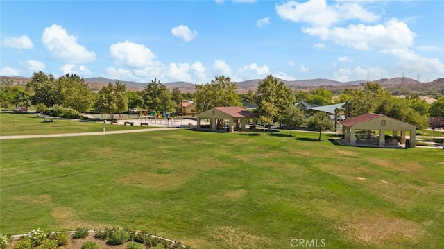 view of property's community with a gazebo, a mountain view, and a lawn