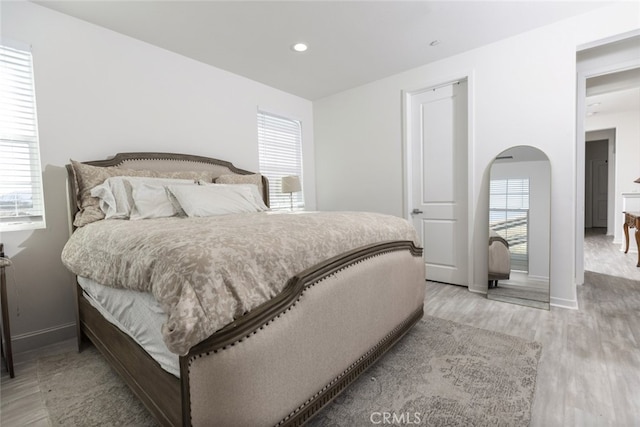 bedroom with light wood-type flooring and multiple windows