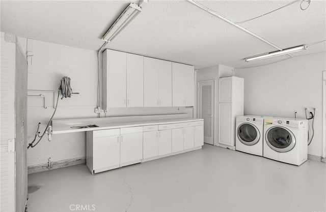 laundry room featuring washing machine and dryer and cabinets