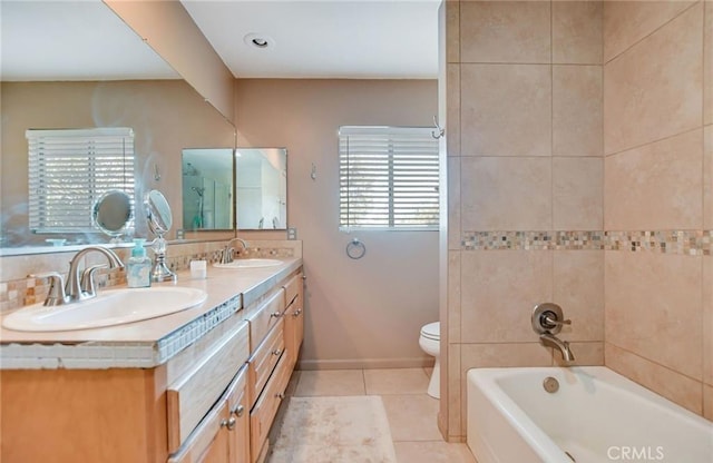 bathroom with toilet, tile patterned floors, a washtub, and vanity