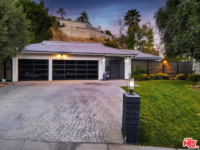 view of front of home with a garage and a yard