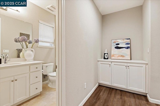 bathroom featuring vanity, toilet, and hardwood / wood-style floors