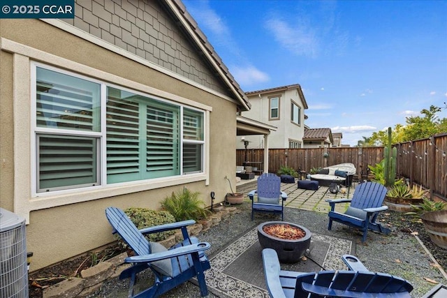 view of patio / terrace featuring central AC and an outdoor living space with a fire pit