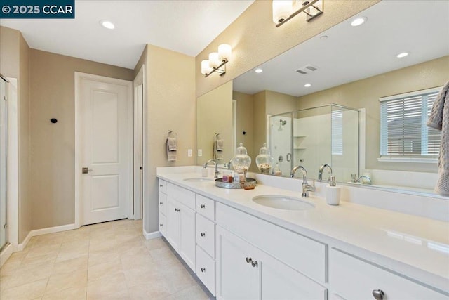 bathroom featuring a shower with door, vanity, and tile patterned flooring