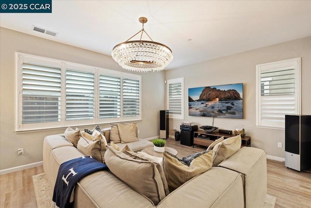 living room featuring light hardwood / wood-style floors and a chandelier