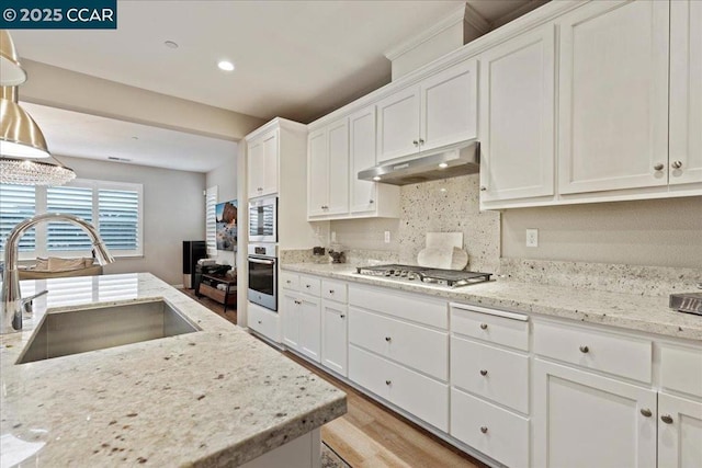 kitchen featuring white cabinetry, appliances with stainless steel finishes, sink, and hanging light fixtures