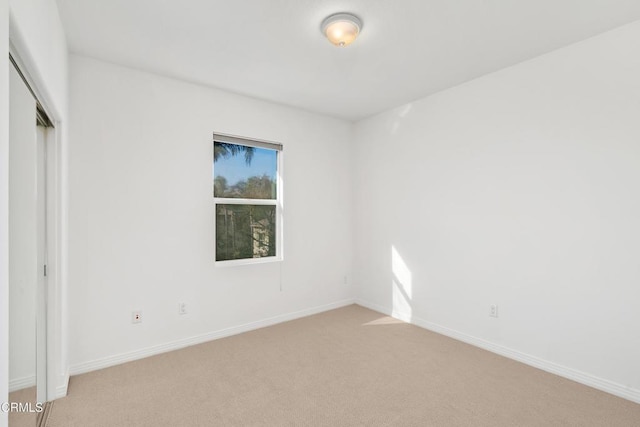 unfurnished bedroom with light carpet and a closet