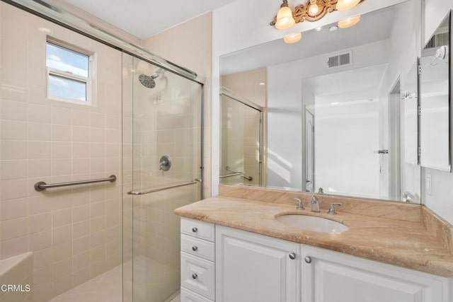 bathroom with a shower with shower door and vanity