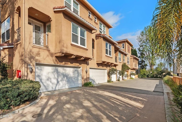 exterior space with driveway, an attached garage, and stucco siding