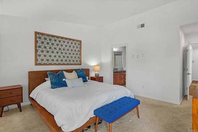 bedroom featuring light colored carpet and ensuite bathroom