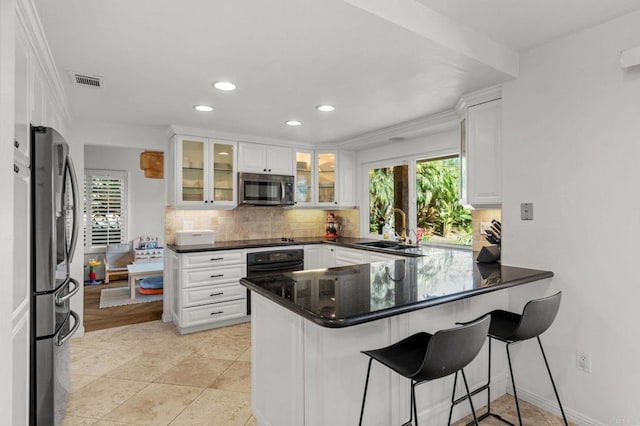 kitchen with sink, stainless steel appliances, kitchen peninsula, and white cabinets