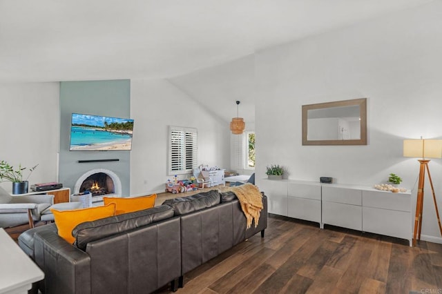 living room featuring vaulted ceiling, dark wood-type flooring, and a fireplace