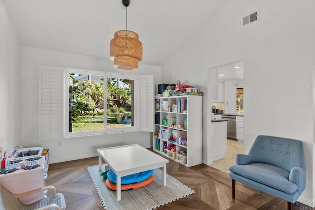 rec room featuring light parquet floors and vaulted ceiling