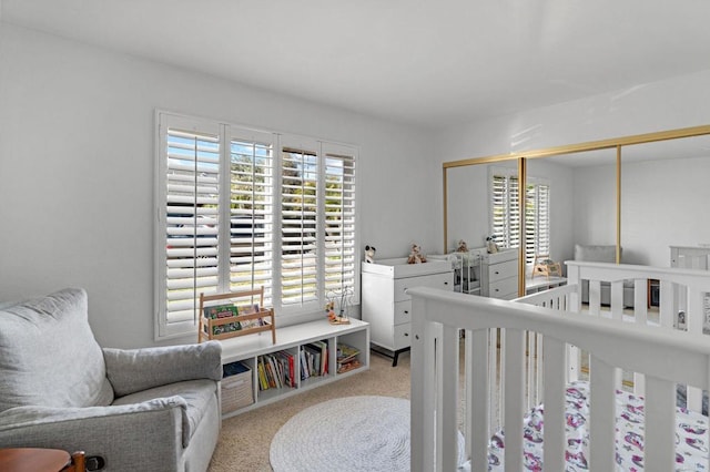 carpeted bedroom featuring multiple windows and a closet