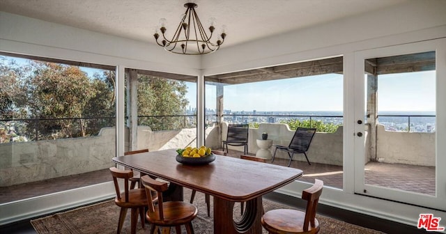 sunroom / solarium with a water view, a healthy amount of sunlight, and a chandelier