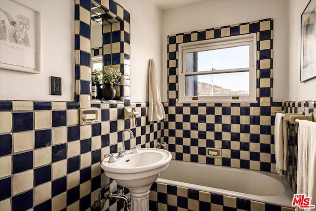 bathroom with tile walls and a bathtub