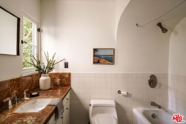 bathroom with a tub, tile walls, toilet, and vanity