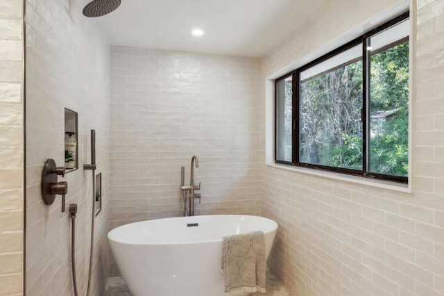 bathroom featuring tile walls and independent shower and bath