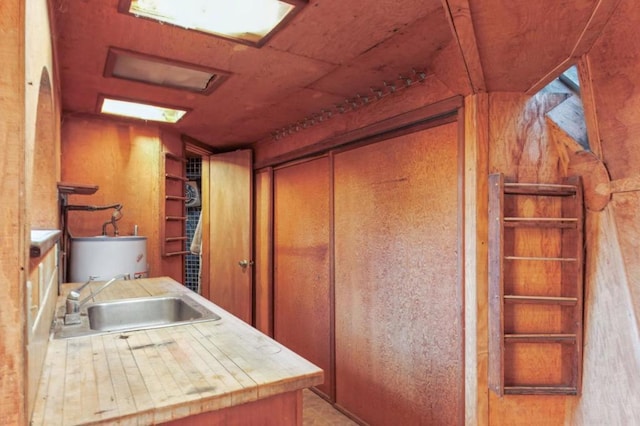 interior space with sink, wood walls, and tile countertops