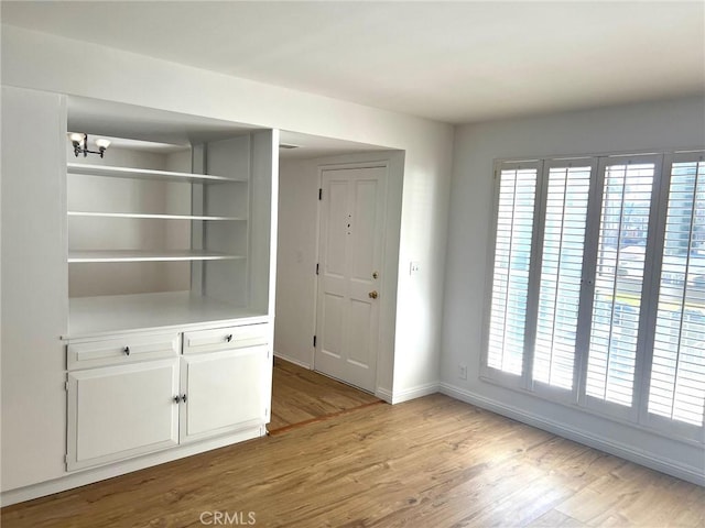 interior space with light wood finished floors and baseboards