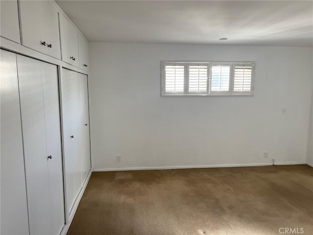 unfurnished bedroom featuring baseboards, a closet, and carpet floors