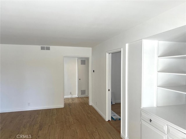 interior space featuring visible vents, baseboards, and wood finished floors