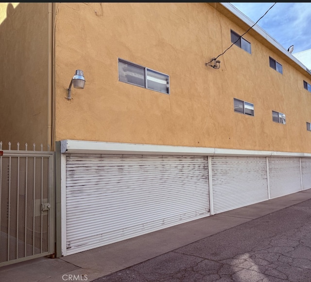 view of home's exterior with stucco siding and fence