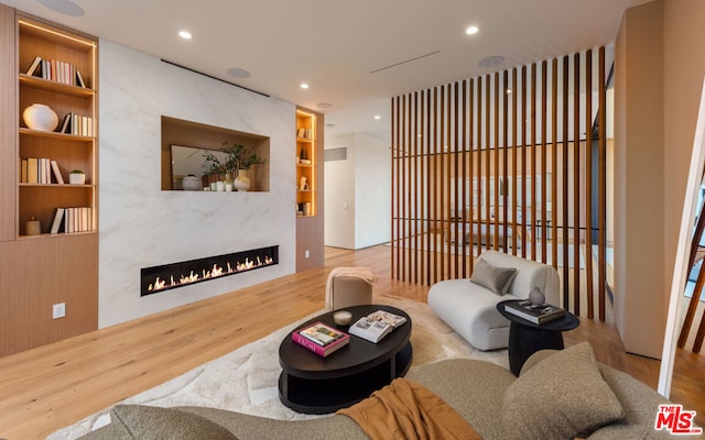 living room featuring built in shelves and hardwood / wood-style flooring