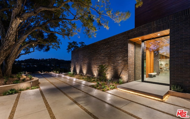 property exterior at night featuring a patio area