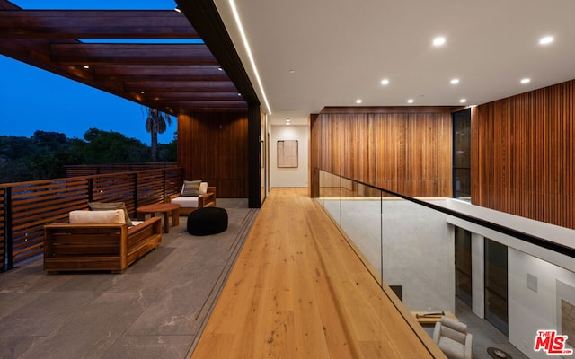 hall featuring wood walls and light wood-type flooring