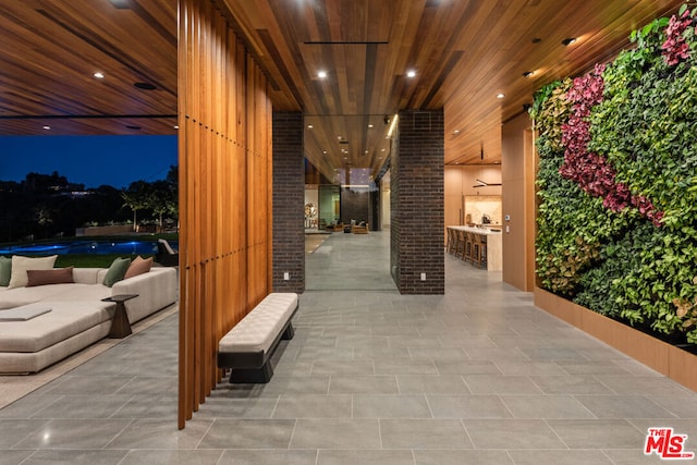 patio at twilight featuring an outdoor bar and a swimming pool