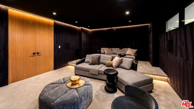 cinema room featuring light colored carpet and wooden walls